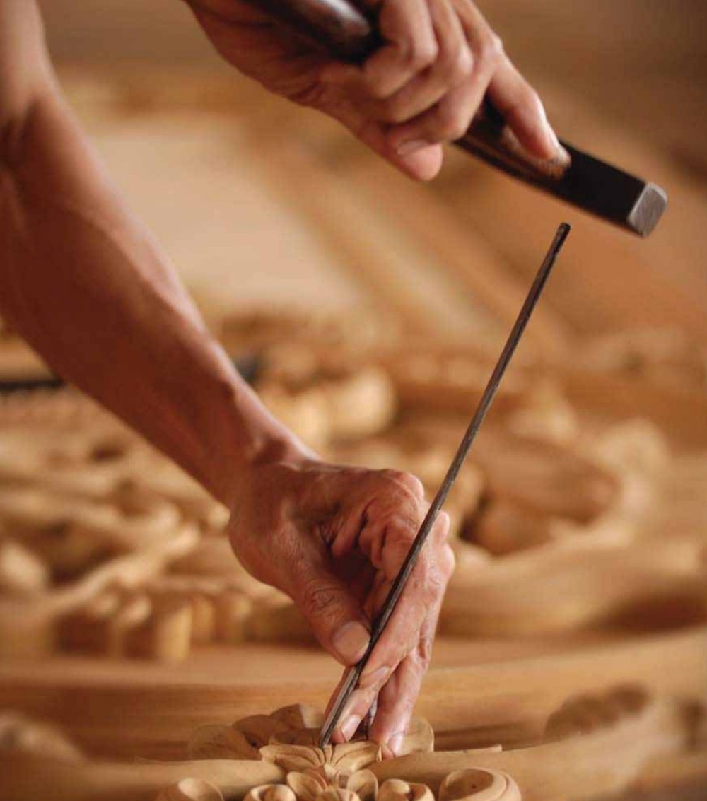Wood craftsman shaping detailed timber work